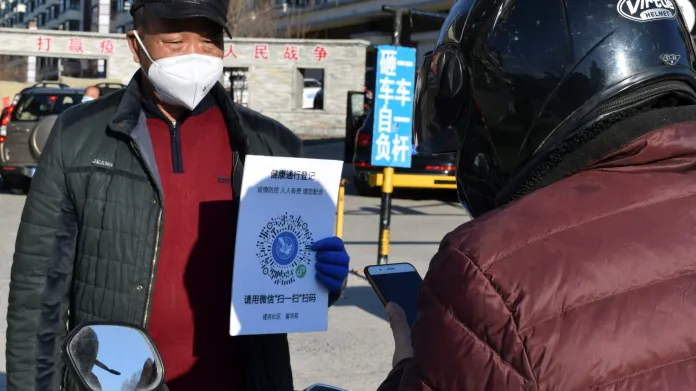 Muž ve městě Suej-fen-che ukazuje QR kód, který potvrzuje jeho zdravotní stav