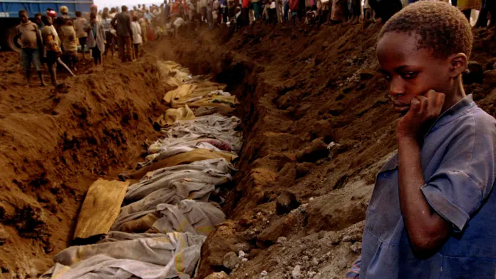 Rwandská dívka stojí u masového hrobu