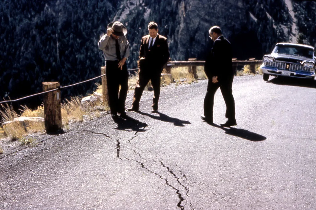 Policista a místní úředníci se dívají na popraskanou silnici po zemětřesení u jezera Hebgen v Yellowstonském národním parku v roce 1959