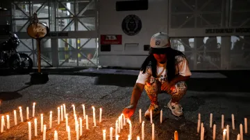 Příbuzní politických vězňů zapalují svíčky během pietní akce před vazebním centrem národní policie