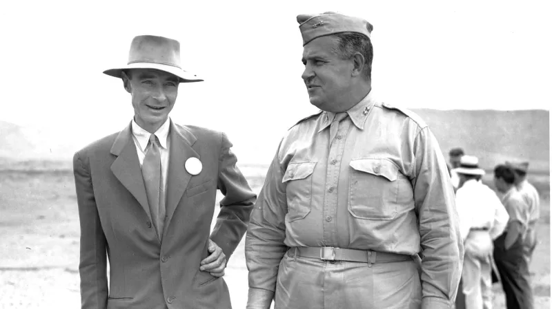 Robert Oppenheimer a generál John Leslie R. Groves, kteří spolupracovali na vývoji atomové bomby, kontrolují základnu věže, ze které byla odpálena zkušební atomová bomba v Alamogordu