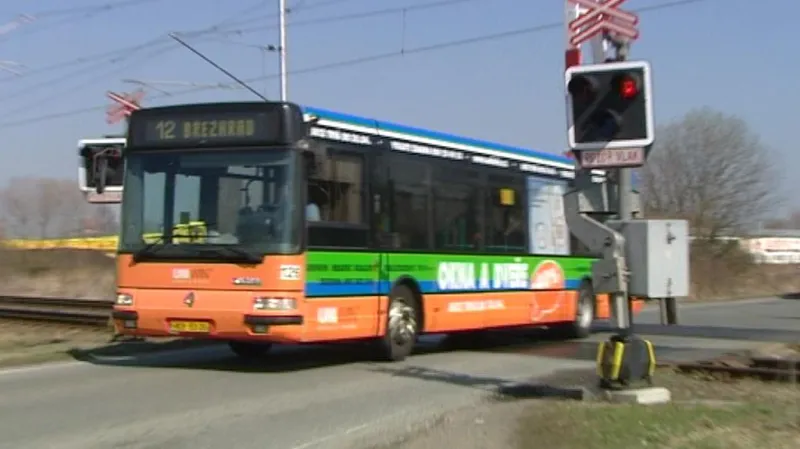 Autobus projíždí přes přejezd na červenou