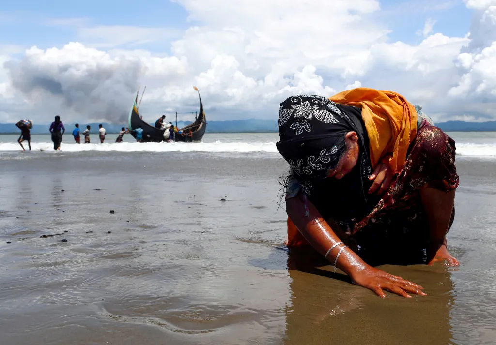 Vyčerpaná Rohingská žena se dotýká břehu poté, co loď, na které uprchla, překročila bangladéšsko-myanmarskou hranici přes Bengálský záliv. Shah Porir Dwip, Bangladéš, 2017