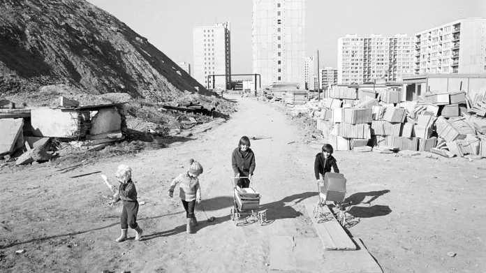 Ambiciozní urbanistický projekt Jižní Město je ve výstavbě. Děti nových osídlenců si hrají v železobetonové džungli v legendární době holínek a bláta. Počátek 80. let a fotografie ze souboru „Sídlištní lidé“ Jaromíra Čejky.
