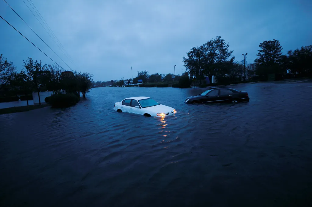Výstražná světla zatopeného auta nepřestávají blikat v stoupající hladině povodní způsobených hurikánem Florence před úsvitem ve městě Wilmington (Severní Karolína)