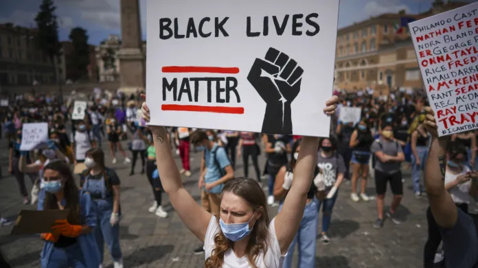 Protestující v Římě drží v rukou transparent