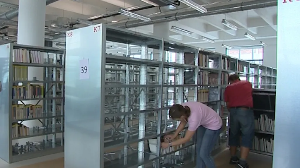 Knihovníci postupně plní regály