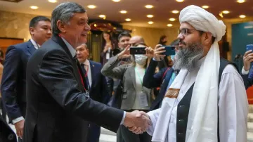 Ruský vyslanec v Afghánistánu Zamir Kabulov si podává ruku se zástupcem delegace Talibanu Mawlawi Shahabuddinem Dilawarem v Moskvě 20. října 2021