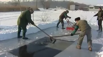 rybáři vyřezávají led v rybníce