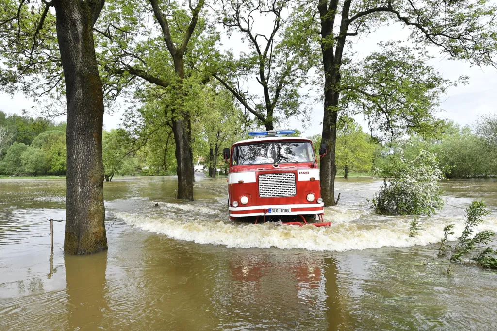Nejen hladinu Bečvy, ale i toky řek v jiných částech Česka zvedly silné deště, na některých místech stále platí pohotovost. Na snímku hasičský vůz projíždí zaplavenou silnicí v obci Černousy na Liberecku