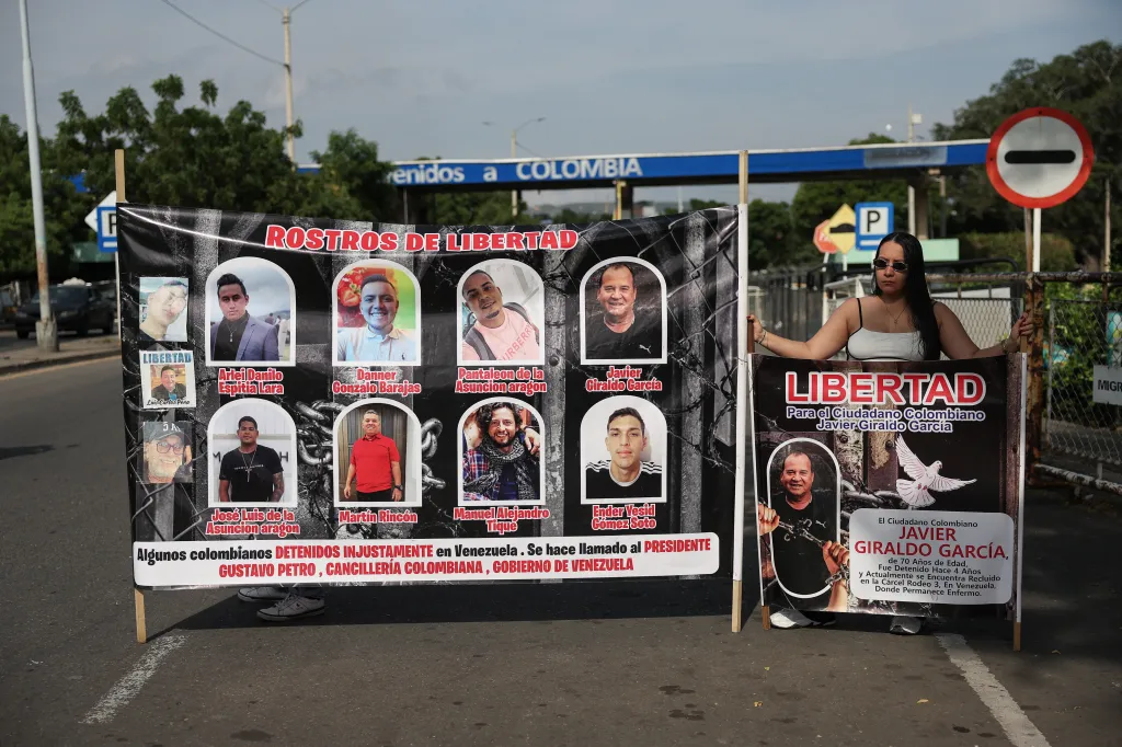 Na hranici mezi Venezuelou a Kolumbií protestovala žena u plakátu, na kterém byli vyobrazeni Kolumbijci věznění ve Venezuele