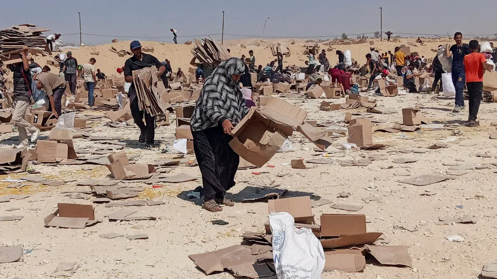 Palestinci si vyzvedávají zbytky humanitární pomoci z distribučního centra Humanitární nadace pro Gazu
