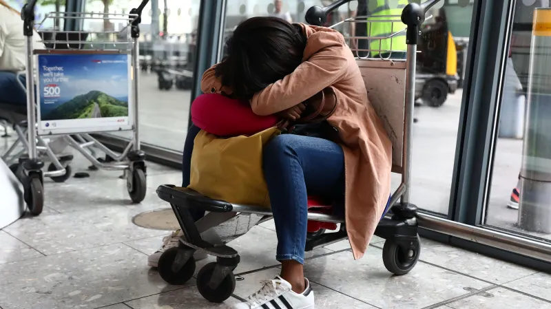 Spící cestující na letišti Heathrow