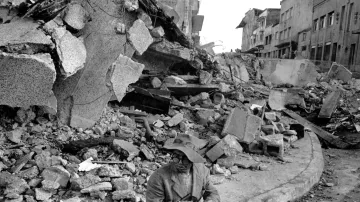 Osamělý obyvatel města Chile na jihu země sedí na obrubníku v centru města poté, co byla sekce zasažena ničivými zemětřeseními. Sutiny v pozadí byly obchodní centrum. Snímek z  30. května 1960