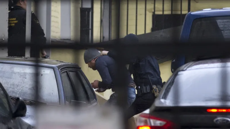 Ruská policie eskortuje jednoho z mužů zadržených v souvislosti s vraždou Borise Němcova