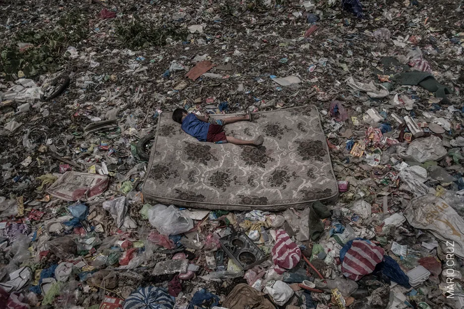 Nominace na vítěznou fotografii v kategorii ŽIVOTNÍ PROSTŘEDÍ (single): Mário Cruz – Chlapec leží na matraci uprostřed odpadků ve filipínské řece Pasig