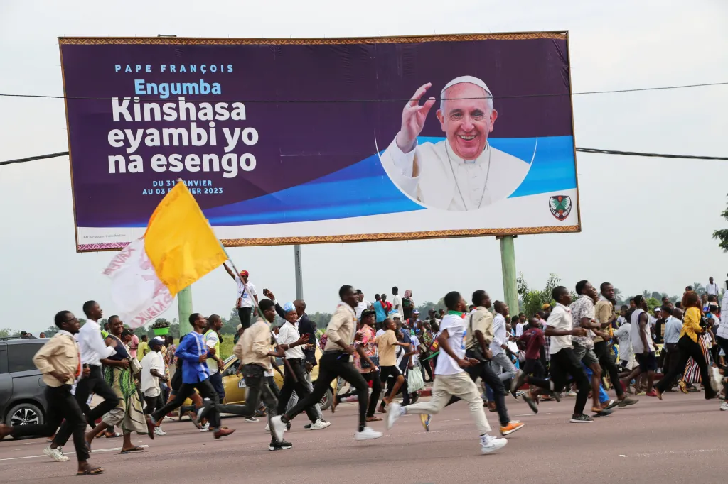 Lidé běží za konvojem papeže Františka