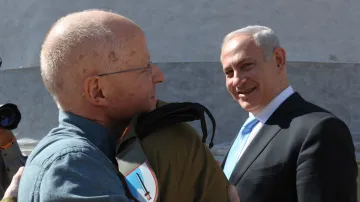 Gilad Šalit se objímá s otcem. Přihlíží Benjamin Netanjahu.