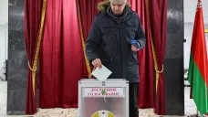 Muž odevzdává svůj hlas během předčasného hlasování běloruských prezidentských voleb v Minsku