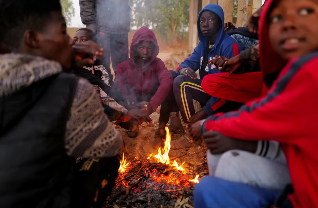 Fallou Diop s dalšími žokeji sedí u ohniště. Za chvíli je čeká ranní trénink