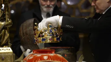 Odborní pracovníci ukládají Svatováclavskou korunu do původního koženého pouzdra z roku 1347.