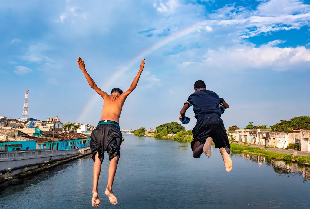 Raúl Navarro, Matanzas na Kubě: Zábava pod duhou

Dvě děti skáčou a hrají si v řece pod jasnou oblohou, přičemž duha v pozadí dodává scéně magický a radostný nádech