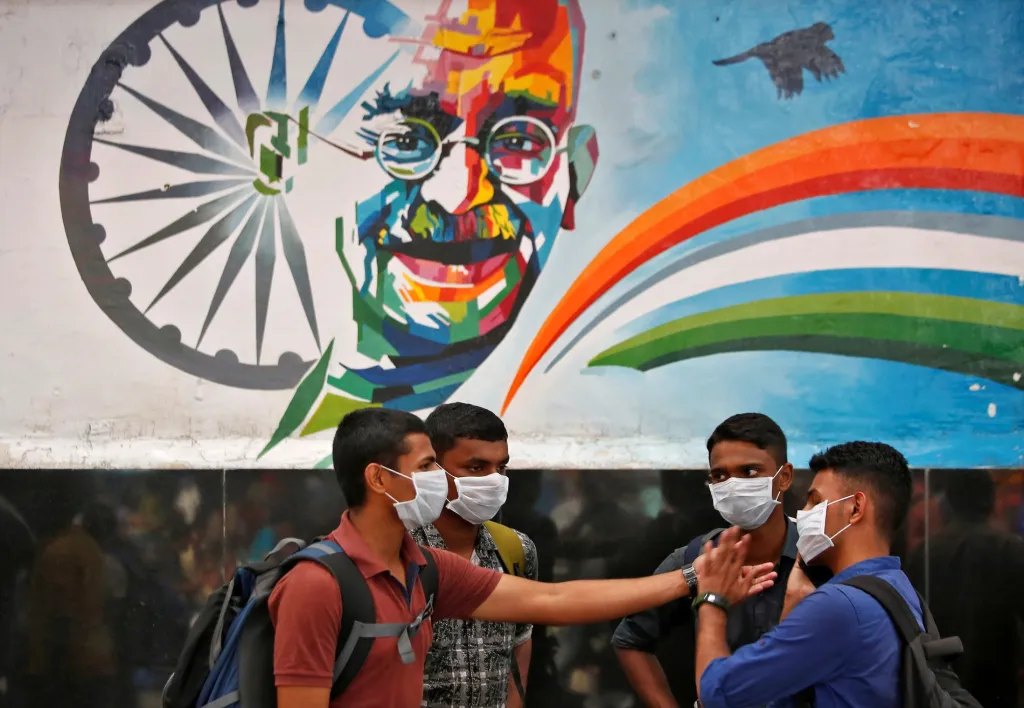 Mladí Indové diskutují pod podobiznou Mahátmy Gándhího, největší duchovní i politické postavy Indie 20. století