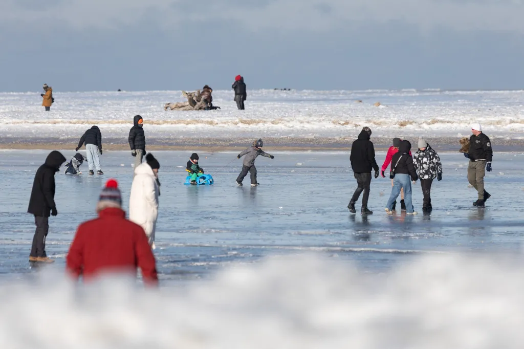 Lidé se procházejí po zamrzlém Baltském moři v Gdaňské zátoce u ústí řeky Visly