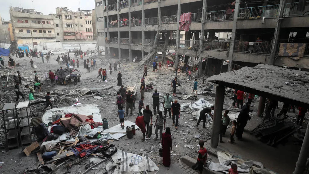 Palestinci ve městě Gaza si prohlížejí škody po nedělním izraelském zásahu školy, která poskytovala vysídleným osobám útočiště (30. 6. 2025)