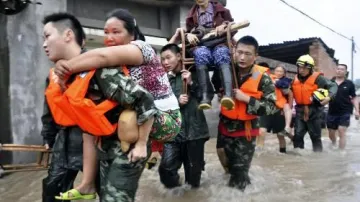 Čínští záchranáři odnášejí lidi zasažené povodněmi