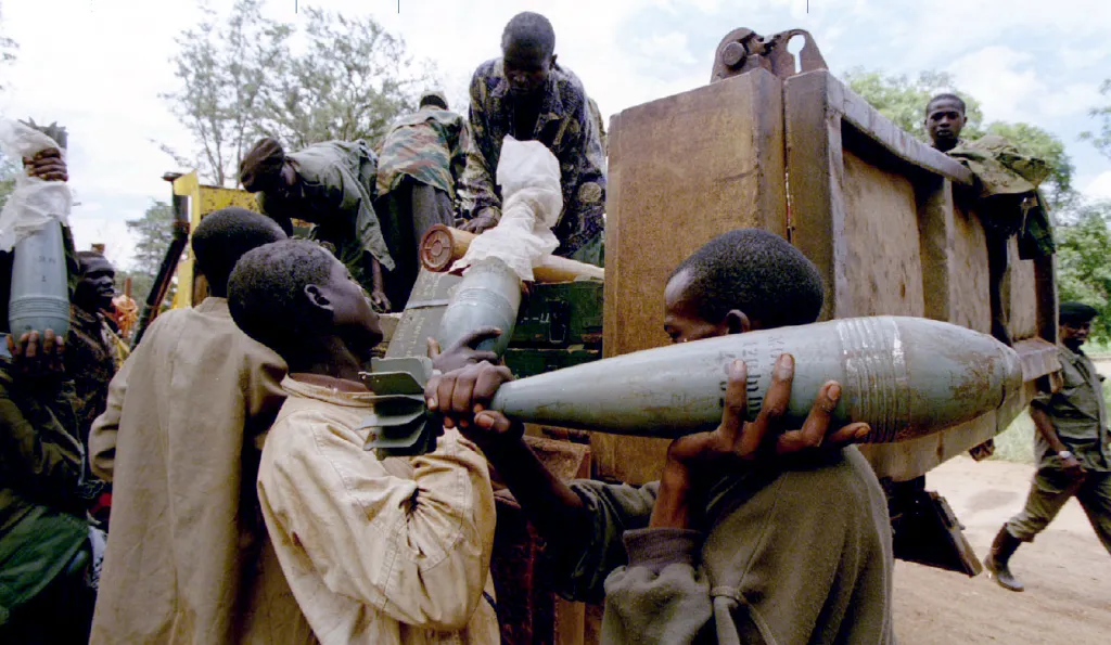 Rebelové z Rwandské vlastenecké fronty (RPF) nakládají munici do nákladního automobilu 23. května 1994 po svém vítězství a převzetí kasáren Kanombe od vládních jednotek
