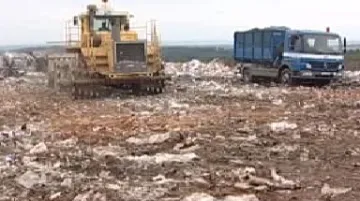 Buldozer upravuje skládku odpadu