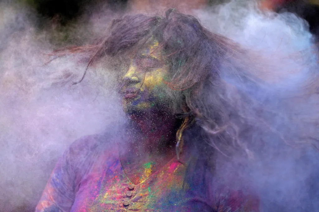 Dívka setřásá z vlasů barevný prach v indické Bobaji