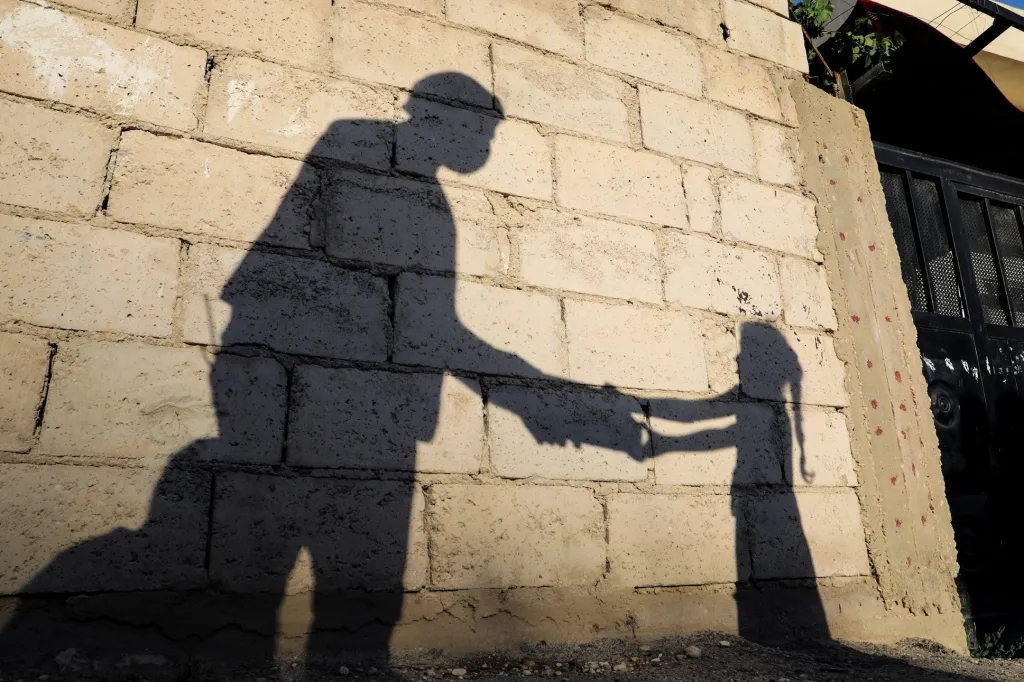 Stín jordánské dívky, která dostává večer jídlo od člena centra humanitárních služeb „Tkiyet Um Ali“. Přísné dodržování ramadánu v některých rodinách má za následek kolapsový stav u dětí. Humanitární služba z toho důvodu preventivně rozdává takto postiženým dětem jídlo