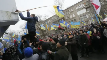 Demonstranti umisťují ukrajinskou vlajku na sídlo ministerstva vnitra