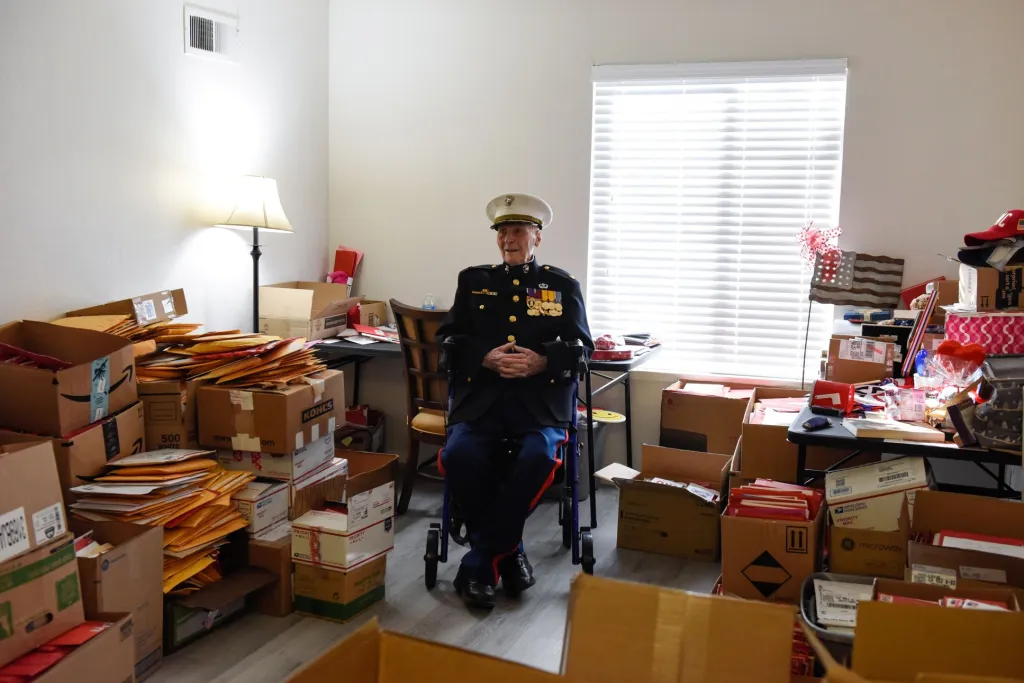 Válečný hrdina sedí u krabic s dopisy svých obdivovatelů