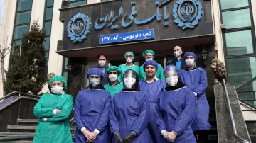 Zaměstnanci banky v Teheránu s ochrannými pomůckami