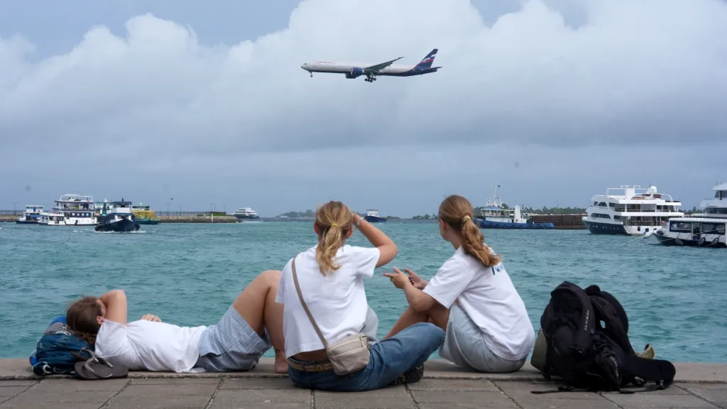 Turisté na Maledivách sledují přistávající letadlo ruské letecké společnosti Aeroflot, 21. května 2026