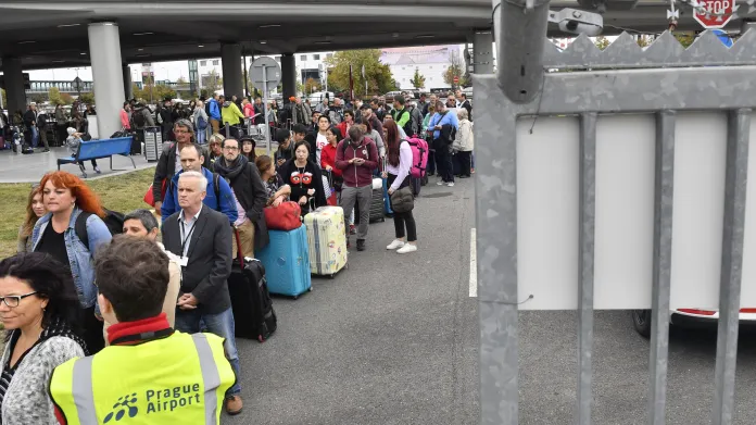 Fronta cestujících u provizorní autobusové konečné na letišti