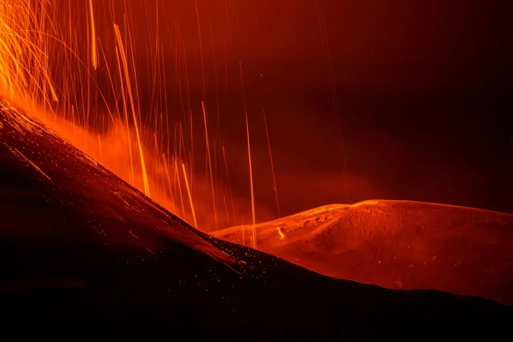 Proudy horké lávy vytékají z kráteru po erupci Etny