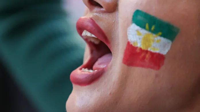 Protesty za lidská práva v Íránu s kurdskou vlajkou na tváři