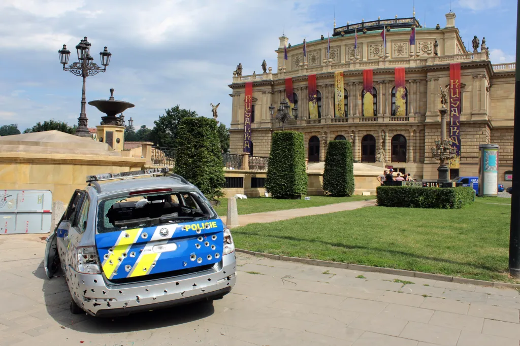 Rozstřílené policejní auto před pražským Rudolfinem, kde pro potřeby filmu vyrostla velká dekorace