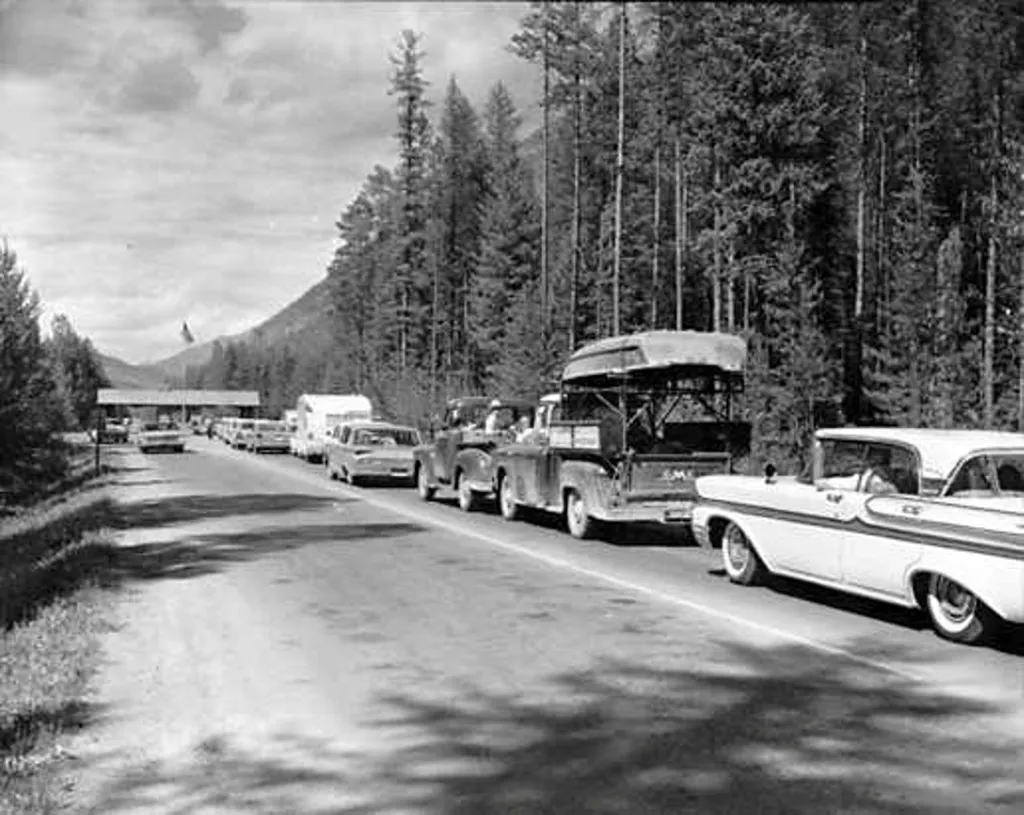 Řada vozidel čeká na povolení vjezdu na západní straně Národního parku Glacier v Montaně v USA v 50. letech