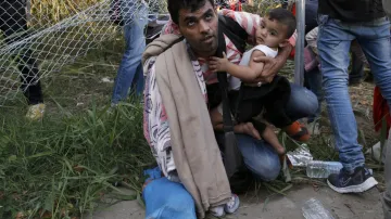Uprchlíci překonávají plot na hranici Srbska a Maďarska
