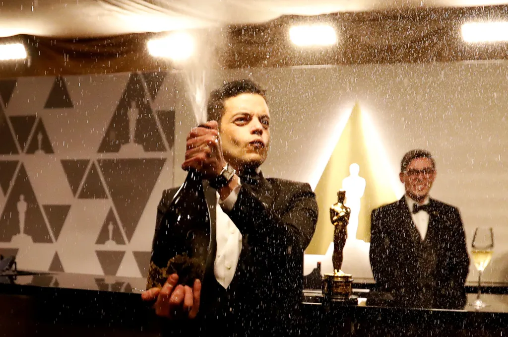 Rami Malek, držitel Oscara za nejlepší mužský herecký výkon v hlavní roli Freddieho Mercuryho ve filmu Bohemian Rhapsody otevírá lahev šampaňského