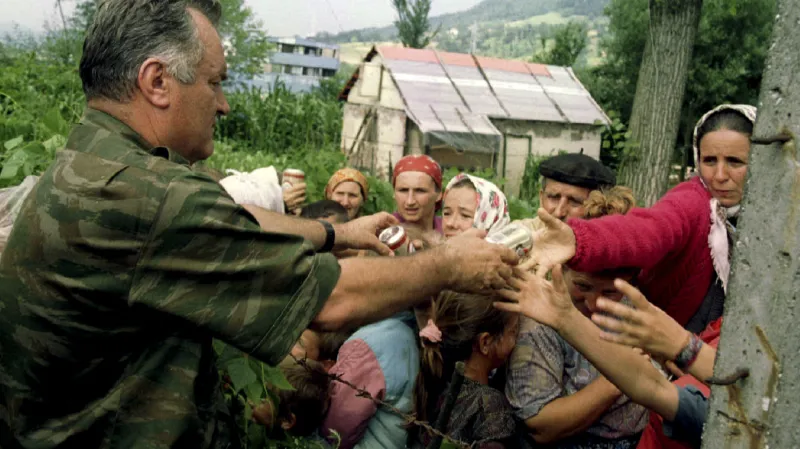 Bosenskosrbský generál Ratko Mladić, pod jehož velením došlo ke genocidě, rozdává potraviny bosňáckým uprchlíkům ve Srebrenici (12. července 1995)