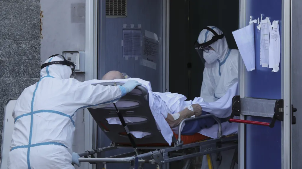 Zdravotníci nesou na nosítkách pacienta nakaženého koronavirem