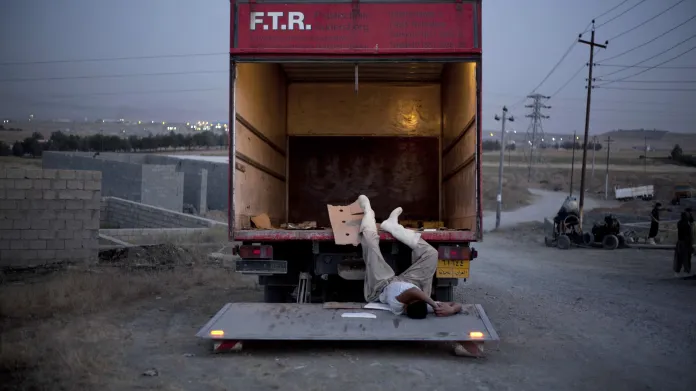 Ali Arkady / Vyčerpaný dělník usíná na nakládací rampě dodávky (8. 6. 2011, Sulajmánija, Irák)
