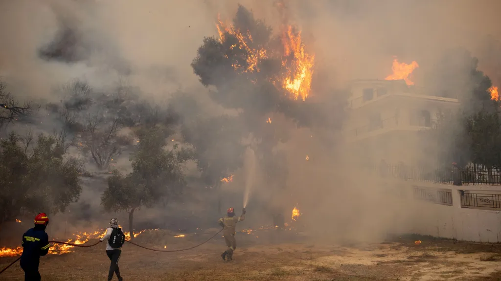 Hasiči s dobrovolníky se snaží vypořádat s plameny nedaleko Athén. Foceno 22. srpna 2023