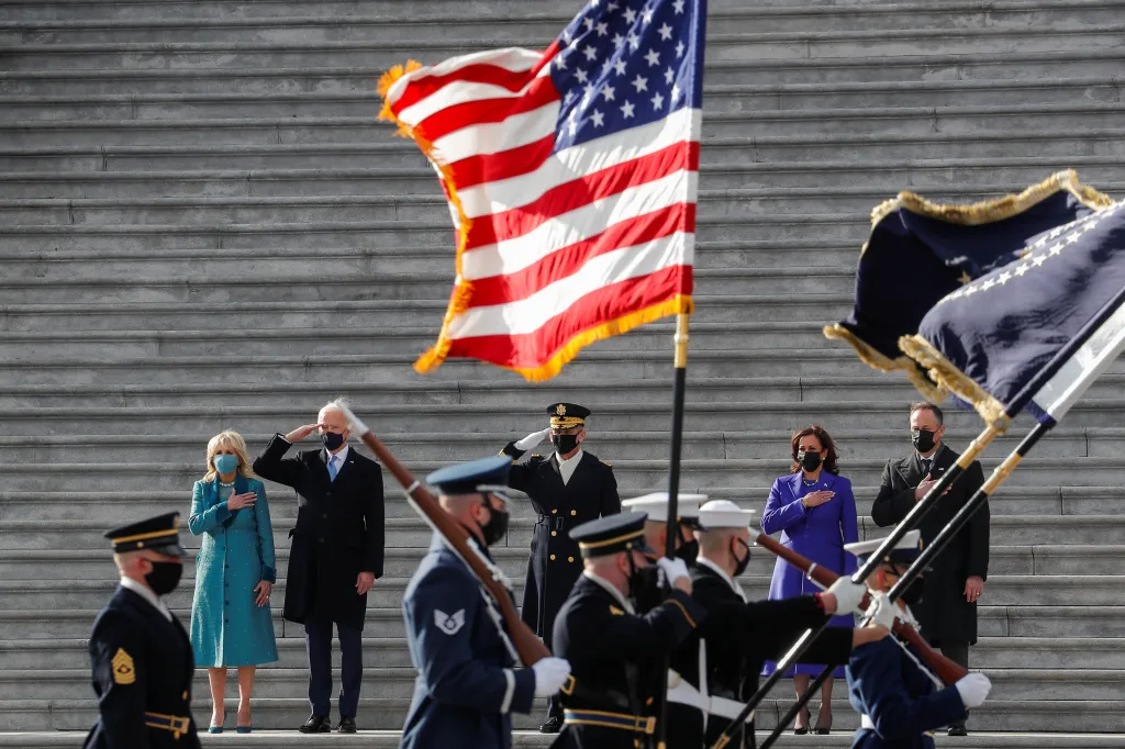 Nově jmenovaný prezident Biden a viceprezidentka Harrisová salutují se svými partnery americké vlajce